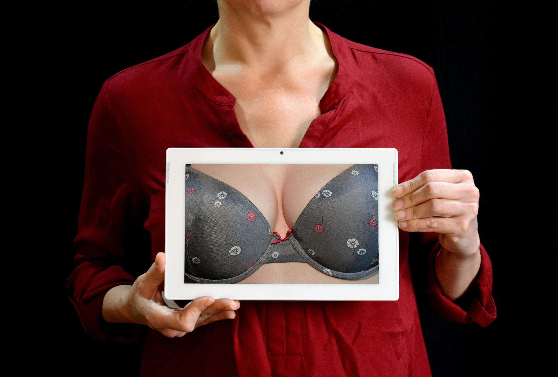 Woman holding picture frame of breast augmentation