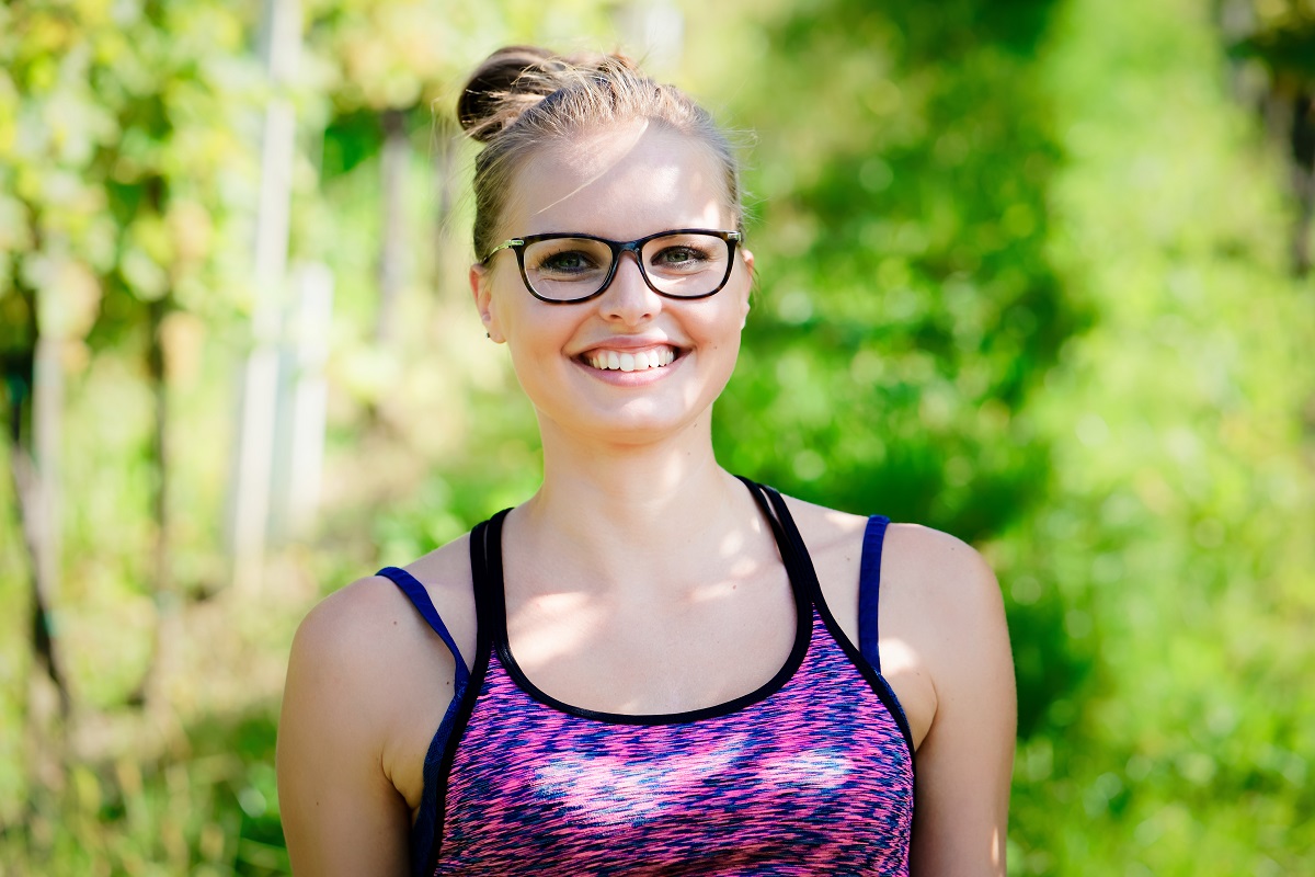 Young beautiful smiling woman in glasses at park