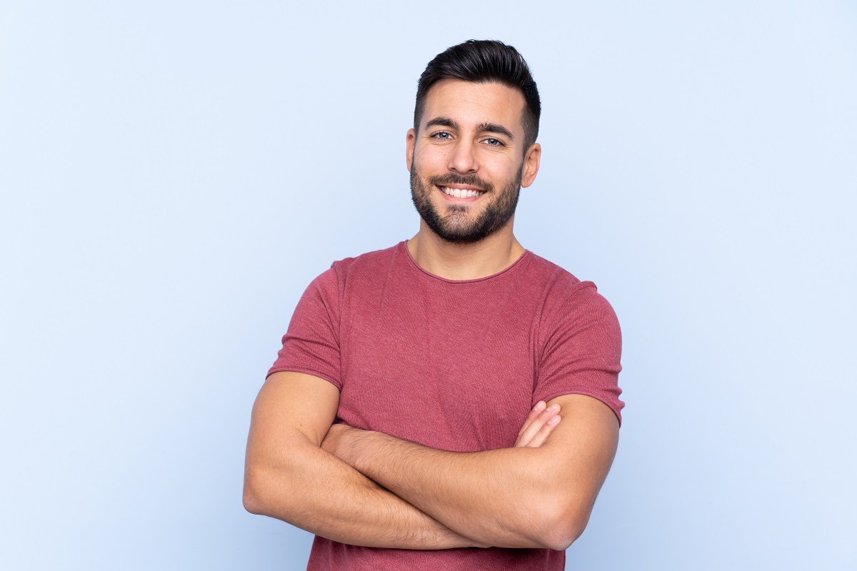 Young handsome man with beard over isolated blue background