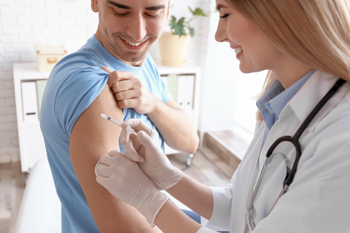 Doctor vaccinating male patient in clinic