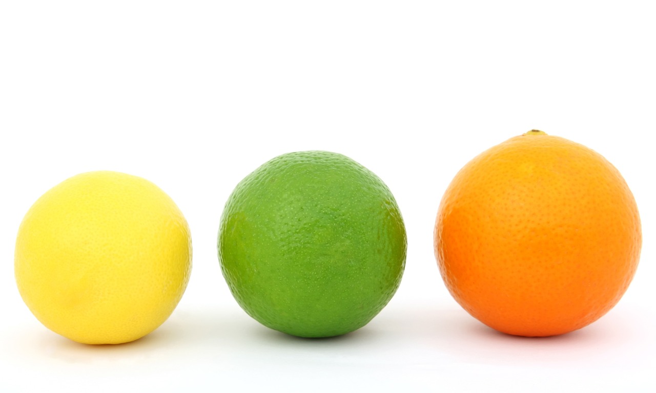 a yellow lemon, a green lime and an red coloured orange