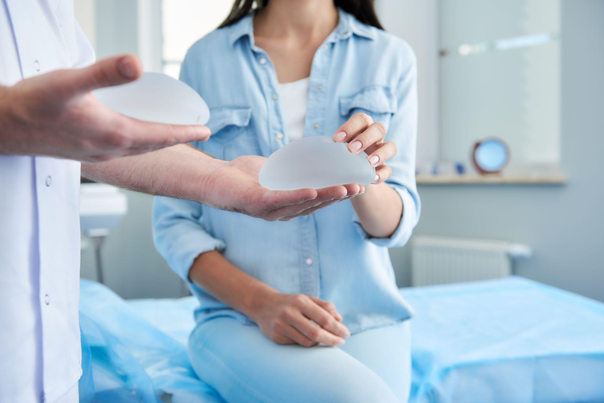 Doctor holding in his hands two silicone implants