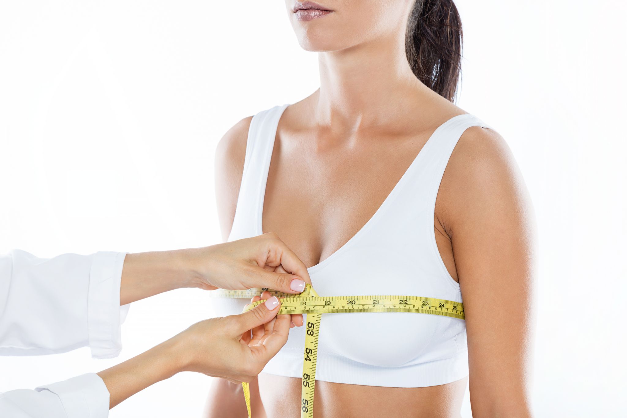 doctor with measure tape measuring the size of the patient's breast.